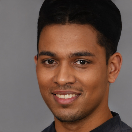 Joyful black young-adult male with short  brown hair and brown eyes
