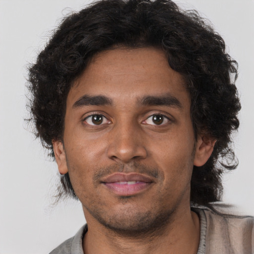 Joyful black young-adult male with short  brown hair and brown eyes