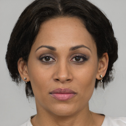 Joyful latino young-adult female with medium  brown hair and brown eyes