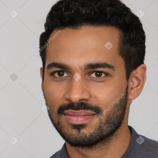 Joyful latino young-adult male with short  black hair and brown eyes