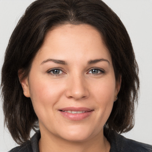 Joyful white adult female with medium  brown hair and brown eyes