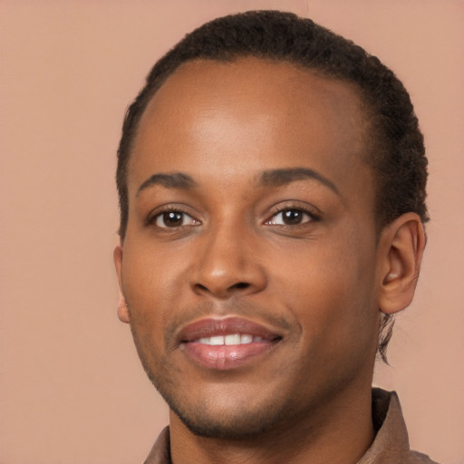 Joyful black young-adult male with short  brown hair and brown eyes