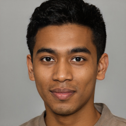 Joyful black young-adult male with short  black hair and brown eyes