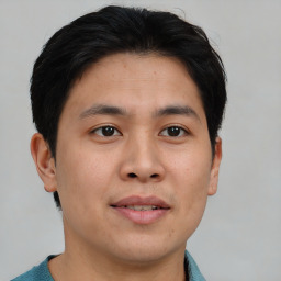 Joyful asian young-adult male with short  brown hair and brown eyes