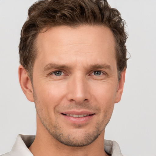 Joyful white adult male with short  brown hair and grey eyes