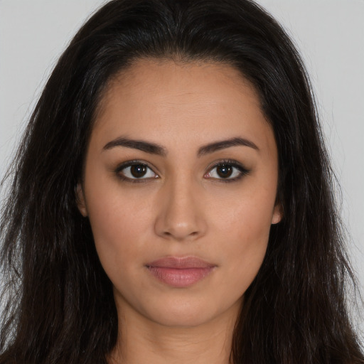 Joyful latino young-adult female with long  brown hair and brown eyes