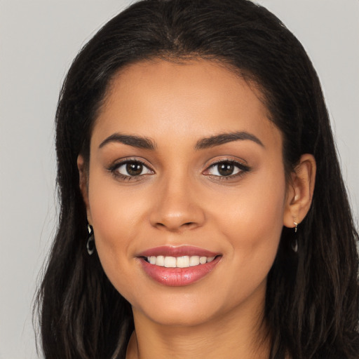 Joyful latino young-adult female with long  brown hair and brown eyes