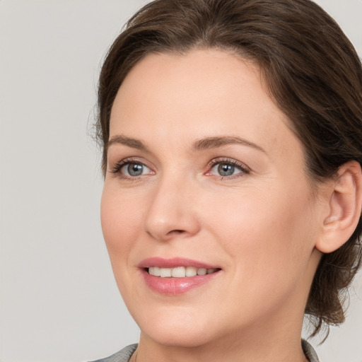 Joyful white adult female with medium  brown hair and grey eyes