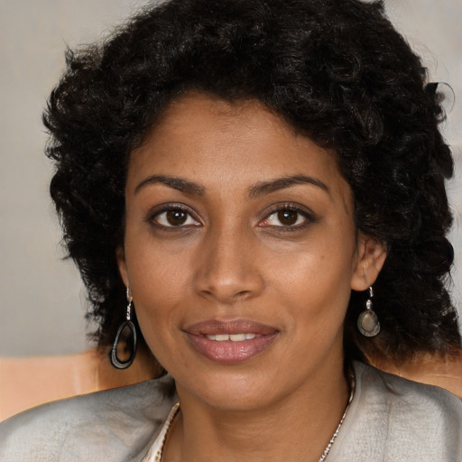 Joyful black young-adult female with long  black hair and brown eyes