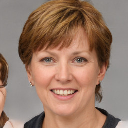 Joyful white adult female with medium  brown hair and blue eyes