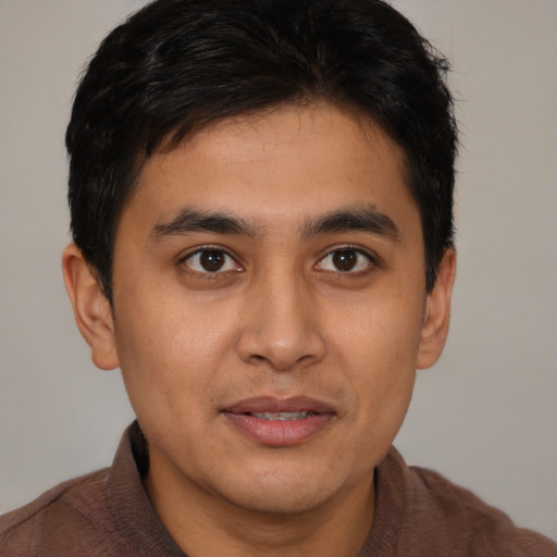 Joyful latino young-adult male with short  brown hair and brown eyes