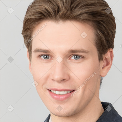 Joyful white young-adult male with short  brown hair and grey eyes