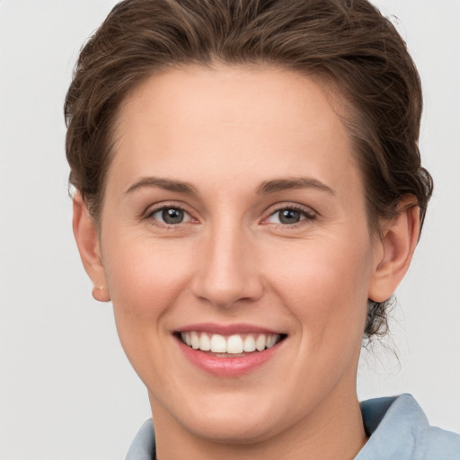 Joyful white young-adult female with short  brown hair and grey eyes