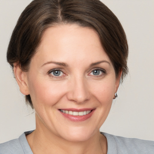 Joyful white adult female with medium  brown hair and grey eyes