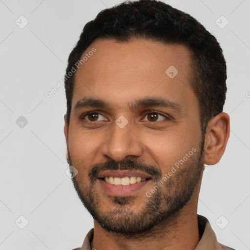 Joyful latino young-adult male with short  black hair and brown eyes