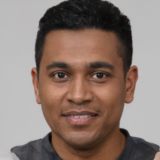 Joyful black young-adult male with short  black hair and brown eyes
