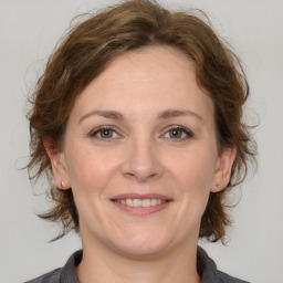 Joyful white adult female with medium  brown hair and grey eyes