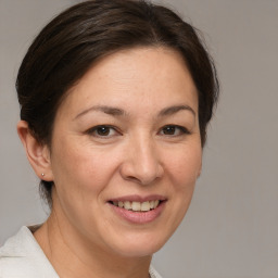 Joyful white adult female with medium  brown hair and brown eyes