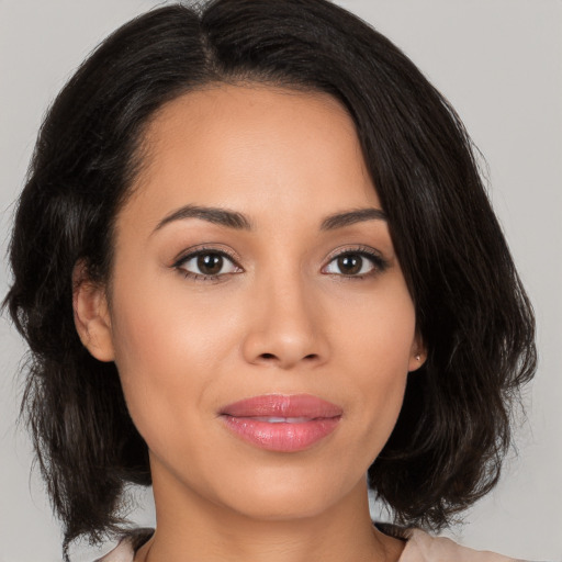 Joyful latino young-adult female with medium  brown hair and brown eyes