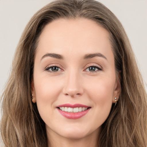 Joyful white young-adult female with long  brown hair and brown eyes