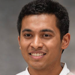 Joyful latino young-adult male with short  brown hair and brown eyes