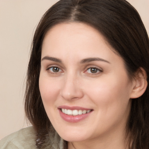 Joyful white young-adult female with long  brown hair and brown eyes