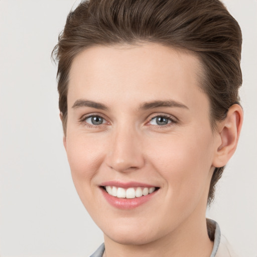 Joyful white young-adult female with short  brown hair and grey eyes