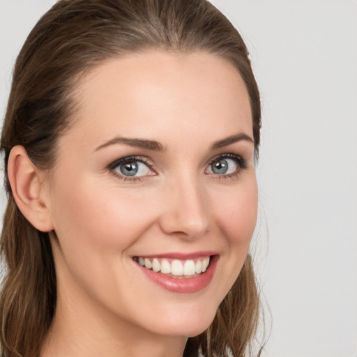 Joyful white young-adult female with medium  brown hair and grey eyes