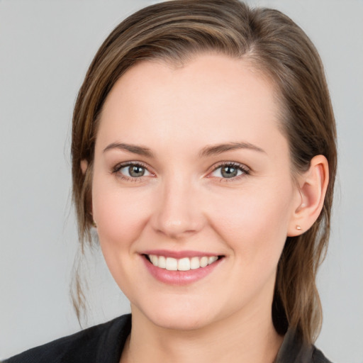 Joyful white young-adult female with medium  brown hair and grey eyes