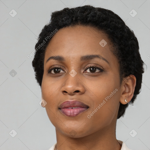 Joyful black young-adult female with short  black hair and brown eyes