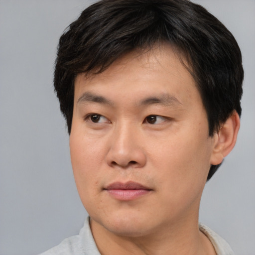 Joyful asian young-adult male with short  brown hair and brown eyes