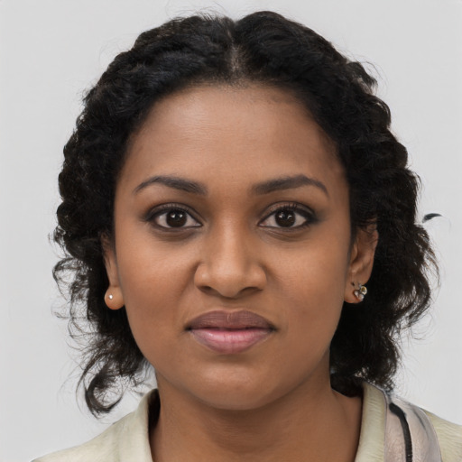 Joyful black young-adult female with long  black hair and brown eyes