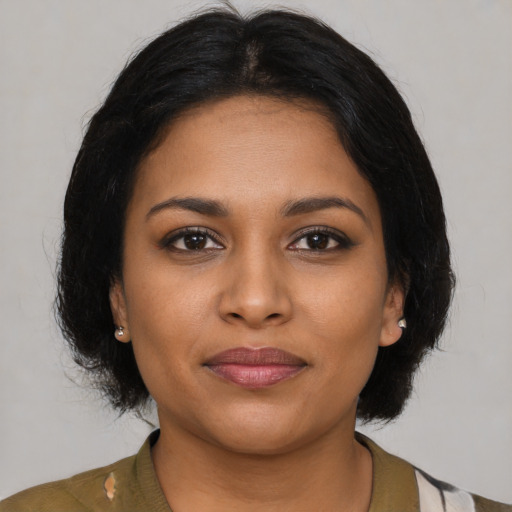 Joyful black young-adult female with medium  brown hair and brown eyes