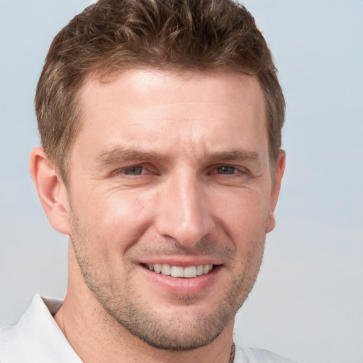 Joyful white adult male with short  brown hair and grey eyes