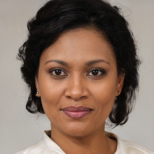 Joyful black young-adult female with medium  brown hair and brown eyes