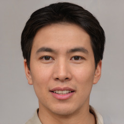 Joyful asian young-adult male with short  brown hair and brown eyes