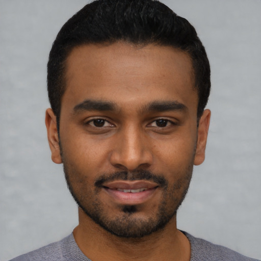 Joyful black young-adult male with short  black hair and brown eyes