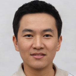 Joyful asian young-adult male with short  brown hair and brown eyes