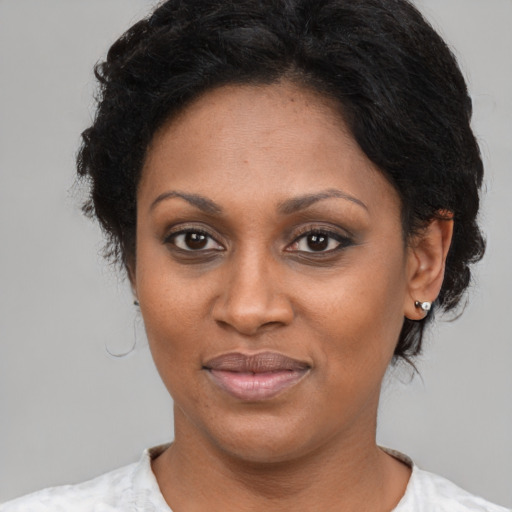 Joyful black adult female with short  brown hair and brown eyes