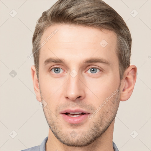 Joyful white young-adult male with short  brown hair and grey eyes