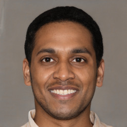 Joyful latino young-adult male with short  black hair and brown eyes