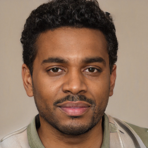 Joyful black young-adult male with short  black hair and brown eyes