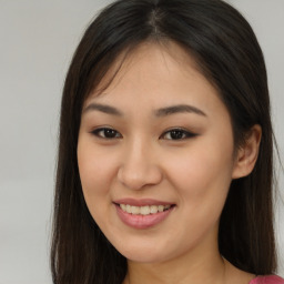 Joyful asian young-adult female with long  brown hair and brown eyes