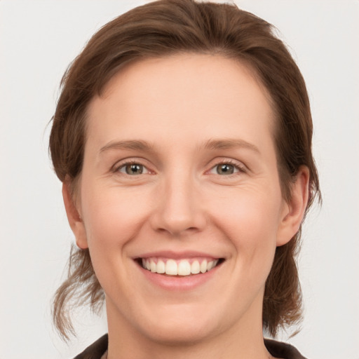 Joyful white young-adult female with medium  brown hair and grey eyes