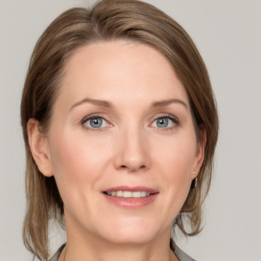 Joyful white adult female with medium  brown hair and grey eyes