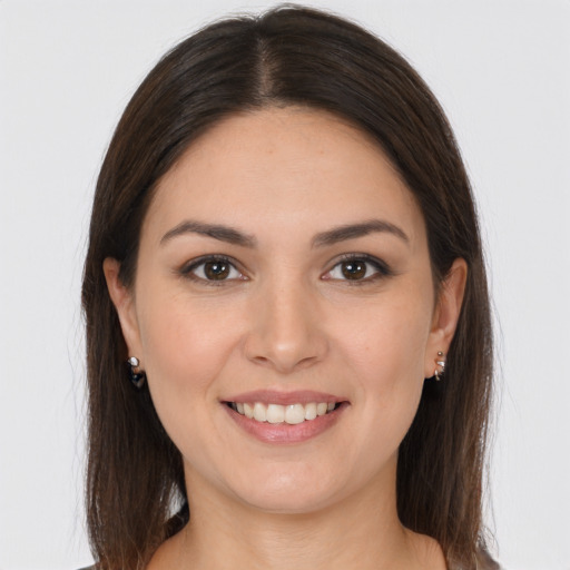 Joyful white young-adult female with long  brown hair and brown eyes