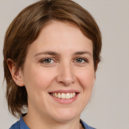 Joyful white young-adult female with medium  brown hair and blue eyes