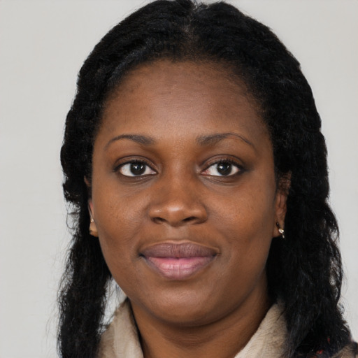 Joyful black young-adult female with long  black hair and brown eyes