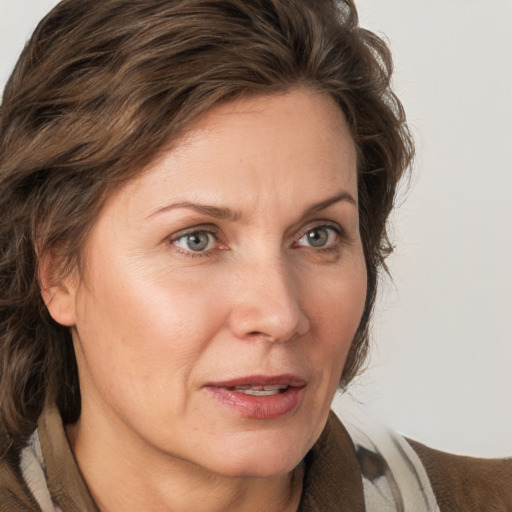 Joyful white adult female with medium  brown hair and grey eyes