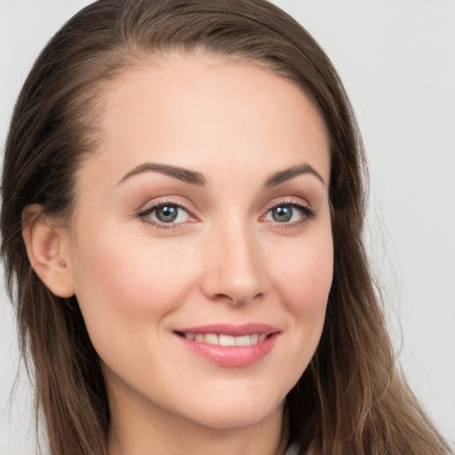 Joyful white young-adult female with long  brown hair and grey eyes